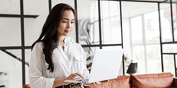 Attractive,Young,Brunette,Asian,Woman,Using,Laptop,Computer,While,Standing